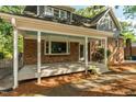 Charming covered porch with painted columns, brick accents, and serene outdoor space at 205 Northfield Dr, Raleigh, NC 27609