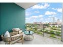 Enjoy the city view from this private balcony with seating and a turquoise accent wall at 214 Hunt St # 701, Durham, NC 27701