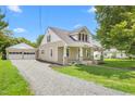 Charming home with detached garage and a well-maintained gravel driveway surrounded by green lawns at 232 S Marshall St, Graham, NC 27253