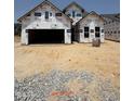 Under-construction home with Tyvek wrap, showing framing and garage opening at 2404 Flemingstone Ln # 51, Raleigh, NC 27610
