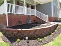 Beautifully landscaped front yard with a brick retaining wall, lush greenery, and a charming lawn at 2662 Walas Ct, Creedmoor, NC 27522