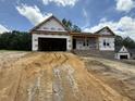 New construction home with a two-car garage and front-facing porch awaits its finishing touches at 299 Little Lady Trail, Zebulon, NC 27597