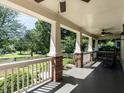 Spacious front porch with brick pillars, railings, and ceiling fans for comfortable outdoor living at 300 W Roanoke Park Dr, Raleigh, NC 27608