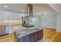 Modern kitchen island with marble countertop, stainless steel appliances, and an elegant range hood at 303 Winhaven St, Roxboro, NC 27573