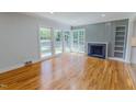 Bright living room featuring a fireplace, light grey wall accent, and hardwood flooring at 303 Winhaven St, Roxboro, NC 27573