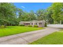 Well-manicured front yard with a long driveway leading to a home featuring mature trees and a welcoming facade at 3315 Swepsonville Saxapahaw Rd, Graham, NC 27253