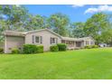 Charming single-story home with a well-maintained lawn, mature trees, and a classic brick exterior with black shutters at 3315 Swepsonville Saxapahaw Rd, Graham, NC 27253