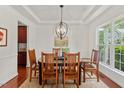 Elegant dining room with a modern chandelier, hardwood floors, and ample natural light from the window at 507 Turmeric Ln, Durham, NC 27713