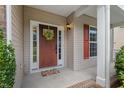 Inviting front porch with a wooden door adorned by a wreath and a colorful doormat at 507 Turmeric Ln, Durham, NC 27713