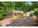 Spacious home with a long covered porch, detached garage, and a shed, all nestled among mature trees at 6022 Little Creek Church Rd, Clayton, NC 27520
