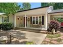 Inviting covered front porch with classic columns, complemented by comfortable seating and decorative touches at 6022 Little Creek Church Rd, Clayton, NC 27520