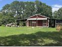 View of a red outbuilding with covered sheds, adding functionality and character to the property at 607 S Smithfield Rd, Knightdale, NC 27545