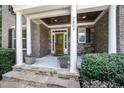 Inviting front porch with stone steps, columns, and space for seating and decor at 7809 Chestnut Branch Ct, Raleigh, NC 27612