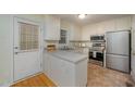 Functional kitchen with stainless steel appliances, white cabinets, and ample countertop space at 8 Mandy Ct, Durham, NC 27707