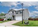 Two-story home featuring a two-car garage, well-kept lawn, and blue skies above at 8005 Caithness St, Raleigh, NC 27616