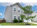 Home's side exterior featuring a well-manicured lawn and attractive gray siding at 8005 Caithness St, Raleigh, NC 27616