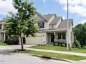 Charming two-story home featuring a welcoming front porch and attached two car garage at 857 Stable Fern Dr, Fuquay Varina, NC 27526