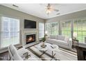 Bright, virtually staged living room featuring a fireplace, large windows, and a comfortable seating arrangement at 8640 Swarthmore Dr, Raleigh, NC 27615