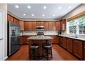 Stylish kitchen with stainless steel appliances, an island with seating, and wood cabinetry at 8715 Macedonia Lake Dr, Cary, NC 27518