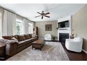 Cozy living room with fireplace, plush seating, and a ceiling fan for comfort at 8715 Macedonia Lake Dr, Cary, NC 27518