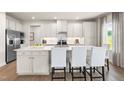 Modern kitchen featuring white cabinets, a large island with seating, stainless steel appliances, and recessed lighting at 892 Nichols View Ct, Raleigh, NC 27604