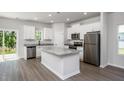 Modern kitchen with stainless steel appliances, an island, white cabinets, and laminate flooring at 1004 Rhino Bnd, Oxford, NC 27565