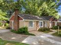 Side view of a well maintained single Gathering home with brick chimney and mature trees at 1040 Ivy Ln, Cary, NC 27511