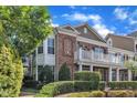 A beautiful brick townhouse featuring a cozy balcony and lush greenery, offering a welcoming curb appeal at 10511 Sablewood Dr # 107, Raleigh, NC 27617