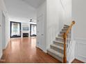 Open floor plan with stairs leading to the upstairs living area and view into the living room at 110 Bonhill Ct, Apex, NC 27502