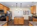 Well-organized kitchen featuring an island, stainless steel fridge, light cabinets, and modern fixtures at 1122 Birkdale Dr, Mebane, NC 27302