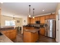 Spacious kitchen with warm wood cabinets, an island, modern stainless steel appliances and durable flooring at 1122 Birkdale Dr, Mebane, NC 27302