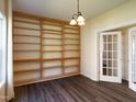 Office featuring built-in bookshelves, modern lighting, hardwood floors, and glass pane french doors at 1122 Birkdale Dr, Mebane, NC 27302