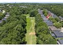 Aerial view of the house with a golf course in the backyard and surrounded by lush greenery and other houses at 12257 Beestone Ln, Raleigh, NC 27614