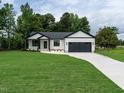 Beautiful one-story home with a black and white color scheme and a long concrete driveway at 1328 Bethlehem Church Rd, Youngsville, NC 27596