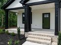 Inviting front porch with classic brick steps and stylish black support columns at 1328 Bethlehem Church Rd, Youngsville, NC 27596