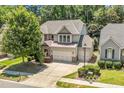 Aerial view of a two-story home with a three car garage and private backyard at 1413 Lily Creek Dr, Cary, NC 27518
