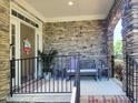 Inviting stone front porch with sitting area, showcasing natural light and charming details at 1413 Lily Creek Dr, Cary, NC 27518