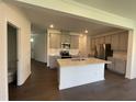 Bright, open-concept kitchen featuring a spacious island and stainless steel appliances, seamlessly connected to living area at 154 N Finley Landing Pkwy, Smithfield, NC 27577