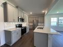 Well-appointed kitchen with stainless steel appliances, gray cabinetry, and a functional island, perfect for meal preparation at 154 N Finley Landing Pkwy, Smithfield, NC 27577