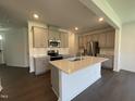 Modern kitchen with a large island, stainless steel appliances, and gray cabinetry, ideal for cooking and entertaining at 154 N Finley Landing Pkwy, Smithfield, NC 27577