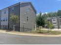 Side view of the townhome showing neutral siding, trimmed lawn, and black metal fence at 1909 Fishamble St # 16, Fuquay Varina, NC 27526