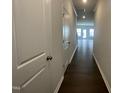 Hallway with dark wood flooring, grey walls, white trim, and natural light at 231 Paramount Dr, Smithfield, NC 27577