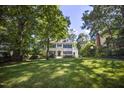 Attractive white home with blue shutters on a large lot with mature trees at 2409 Basil Dr, Raleigh, NC 27612