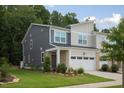 Well-maintained two-story townhouse with brick accents, a two-car garage and green front yard at 273 Millennium Dr, Pittsboro, NC 27312
