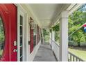 Charming covered front porch with hanging ferns and red shutters creating a cozy outdoor space at 2750 Michelle Ct, Creedmoor, NC 27522