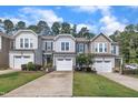 Row of two-story townhomes with attached garages, lush green lawns and blue skies at 287 White Oak Ridge Dr, Garner, NC 27529