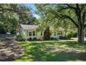 A beautiful home shaded by mature trees and features a well-kept lawn and landscaping at 3005 Piney Grove Wilbon Rd, Holly Springs, NC 27540