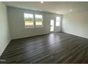 Spacious living room with natural light, laminate wood flooring, and a patio exit at 369 Thompson Overlook Way, Smithfield, NC 27577