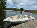 Pleasant view of a parked boat by a weathered dock near a bridge, and calm water, under a partly cloudy blue sky at 394 Flanagan Rd, Henderson, NC 27537