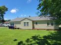 Spacious backyard with lush green grass, showcasing the home's exterior and ample outdoor space at 411 W Raleigh St, Siler City, NC 27344
